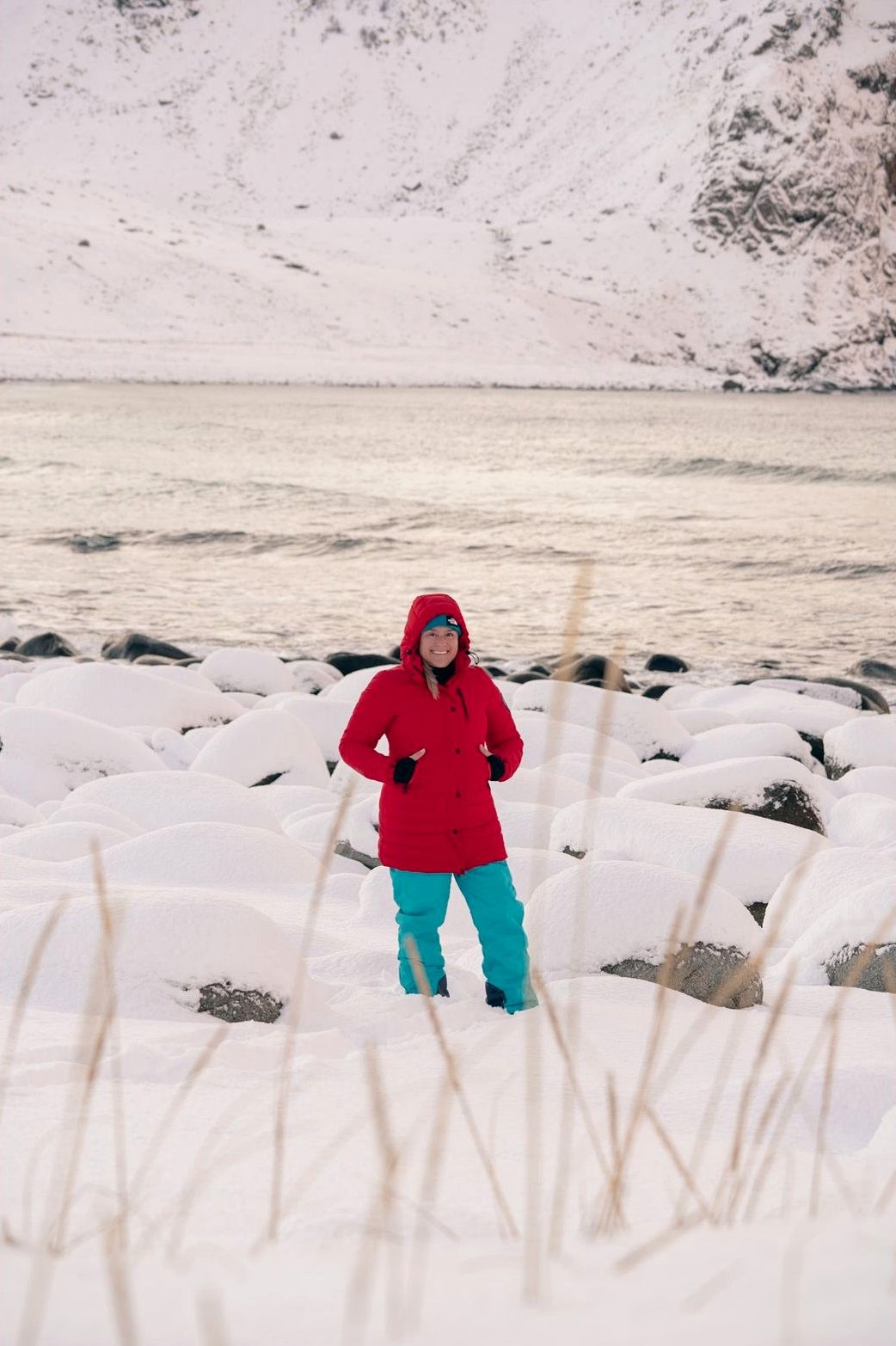 Viajera con chaqueta roja junto a la orilla nevada