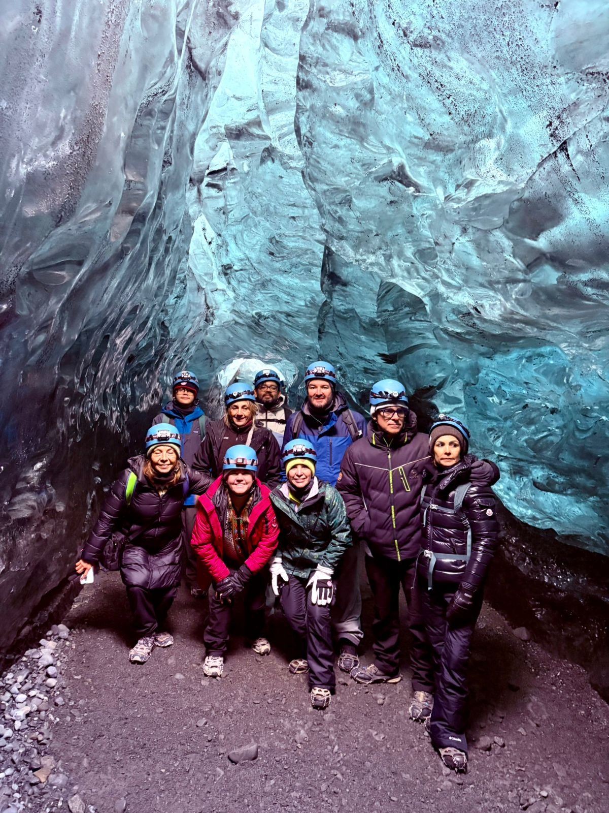 Grupo de viajeros reunidos bajo paredes de hielo azul