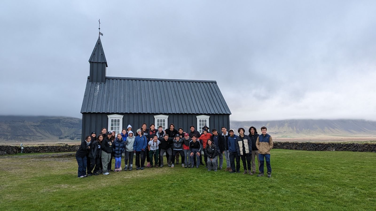 Viajeros reunidos frente a una iglesia de madera negra