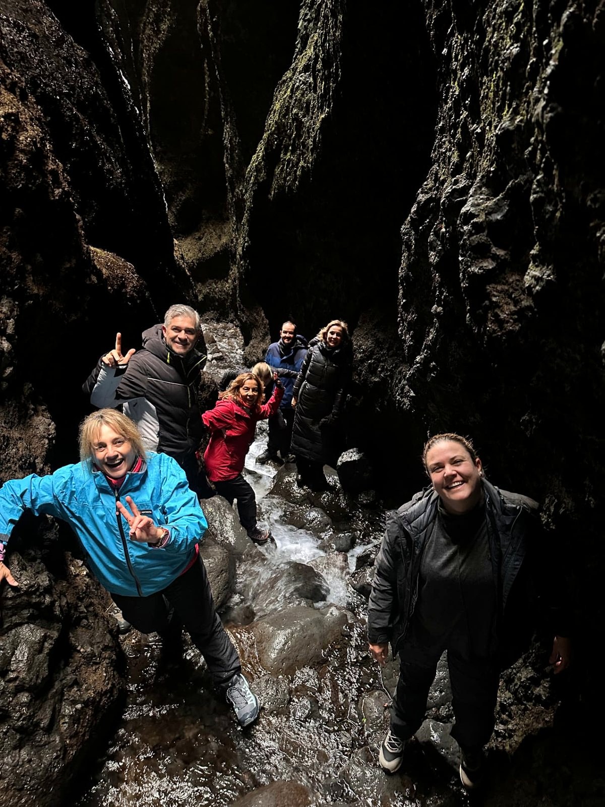 Viajeros entre paredes de roca junto a una cascada