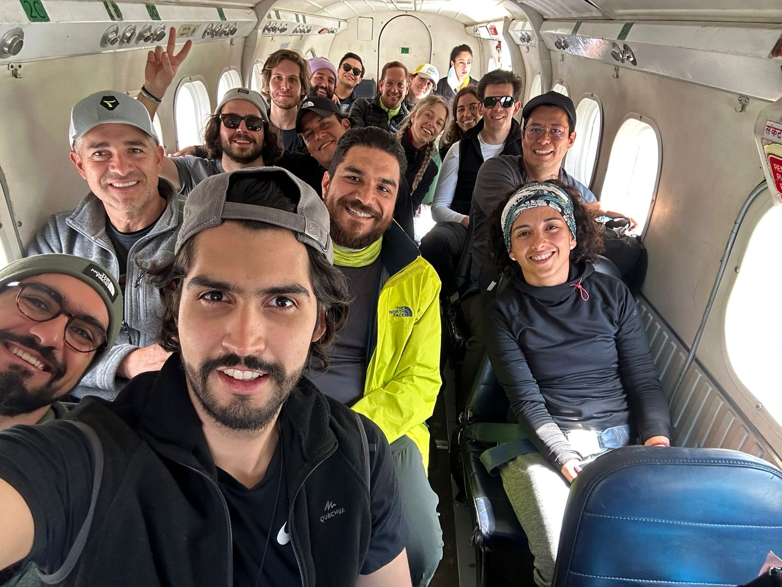 Grupo de viajeros sonriendo dentro de un avión