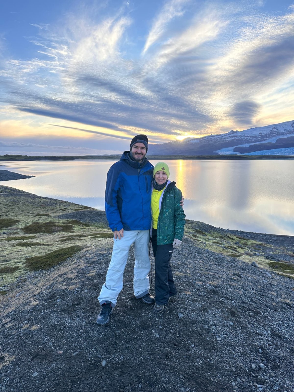 Pareja frente a un lago al atardecer