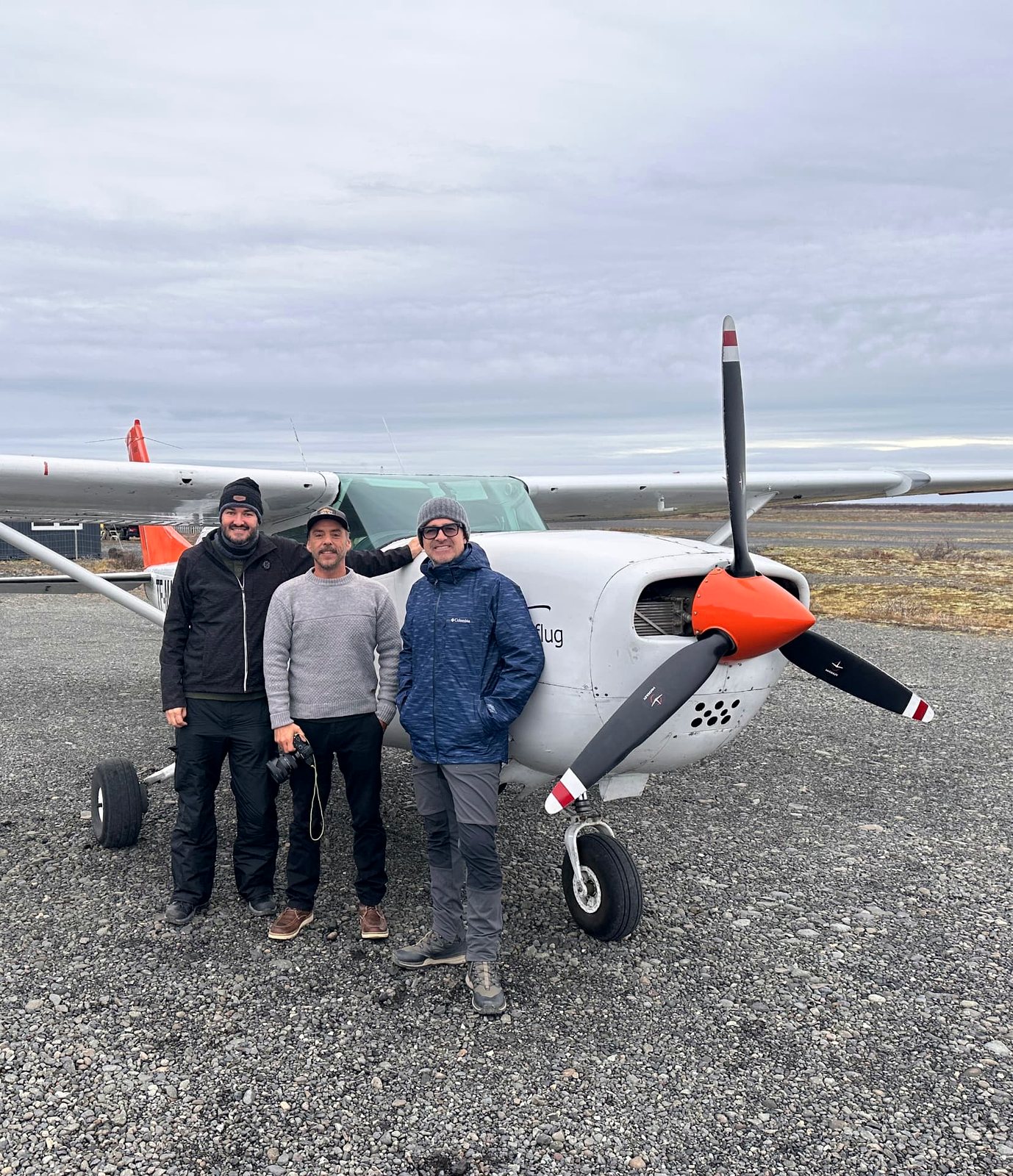 Tres viajeros junto a una avioneta