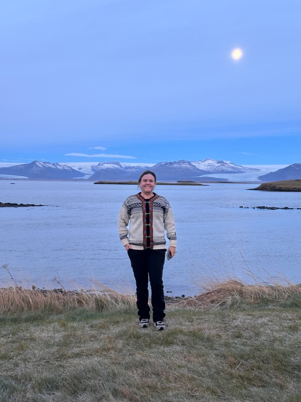 Viajera frente a un lago bajo la luna