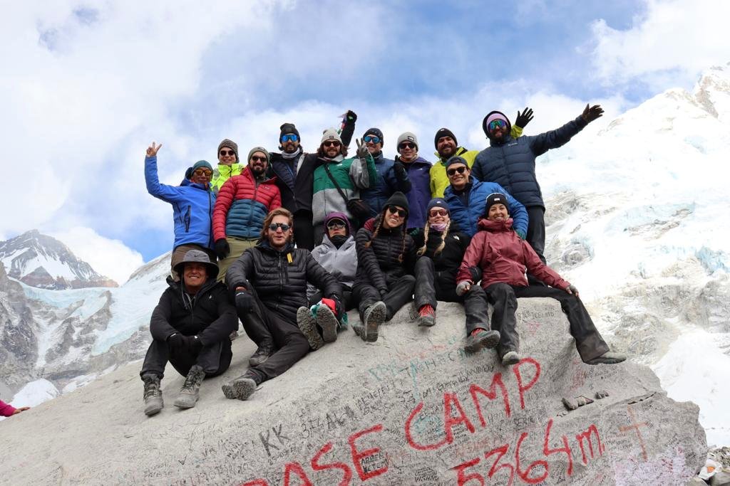 Grupo de viajeros celebrando sobre una roca en la montaña